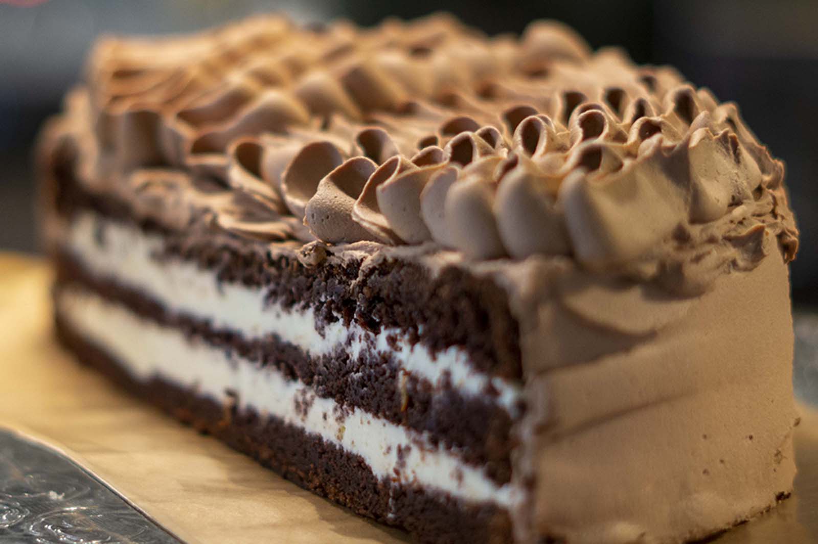 trelags sjokoladekake med sitronkremfyll i midten og sjokoladekrem på toppen og rundt